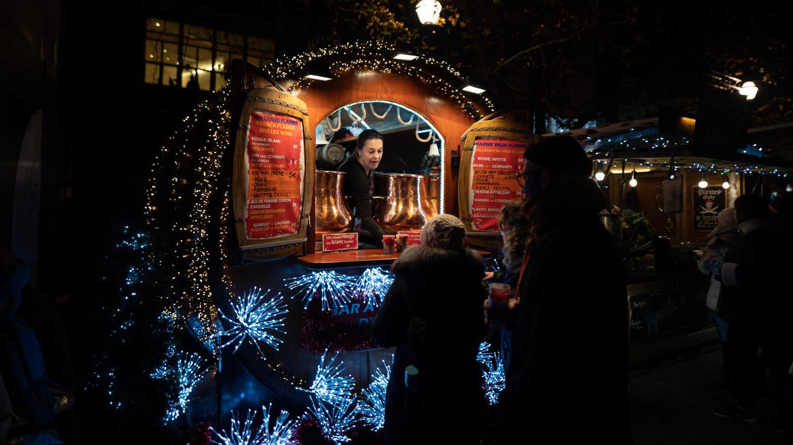 Un stand du marché de Noël illuminé de guirlandes bleues et dorées