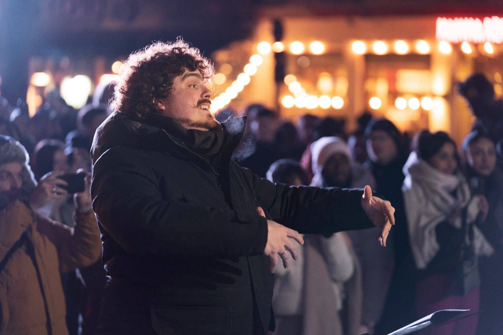 Le chef de chœur dirige, la foule derrière lui